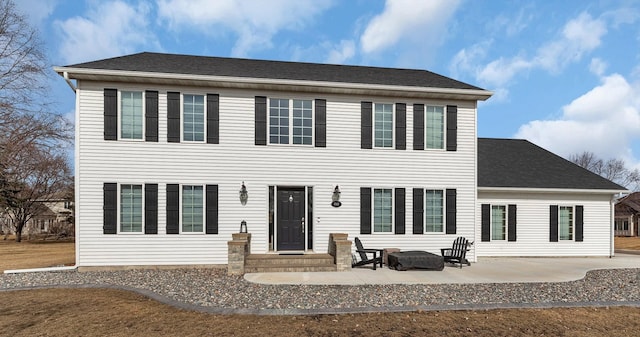 view of front of property featuring roof with shingles and a patio area