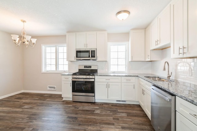 kitchen featuring a sink, appliances with stainless steel finishes, dark wood finished floors, and white cabinets