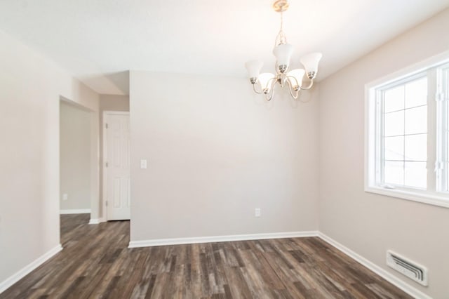 unfurnished room with dark wood-style floors, visible vents, an inviting chandelier, and baseboards