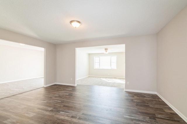 unfurnished room with baseboards and wood finished floors