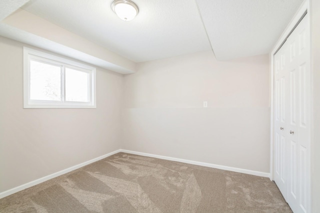 carpeted empty room featuring baseboards