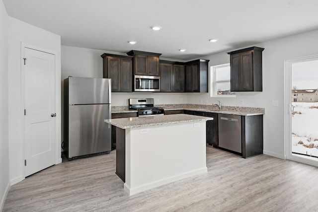 kitchen with a center island, dark brown cabinetry, recessed lighting, light wood-style flooring, and appliances with stainless steel finishes