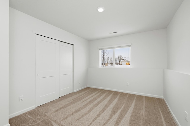 unfurnished bedroom with visible vents, carpet floors, and baseboards