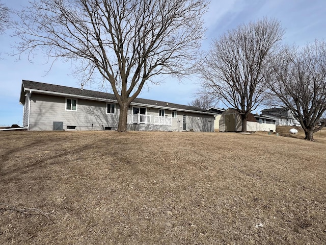 back of property featuring a storage shed and an outbuilding