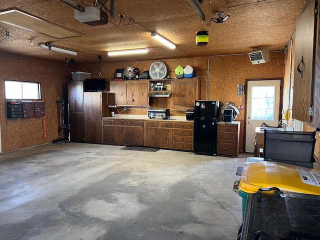 garage featuring a garage door opener and freestanding refrigerator