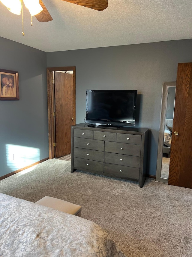 bedroom with a ceiling fan, carpet, and a textured ceiling