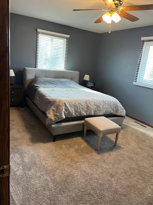 bedroom featuring carpet flooring, baseboards, visible vents, and ceiling fan