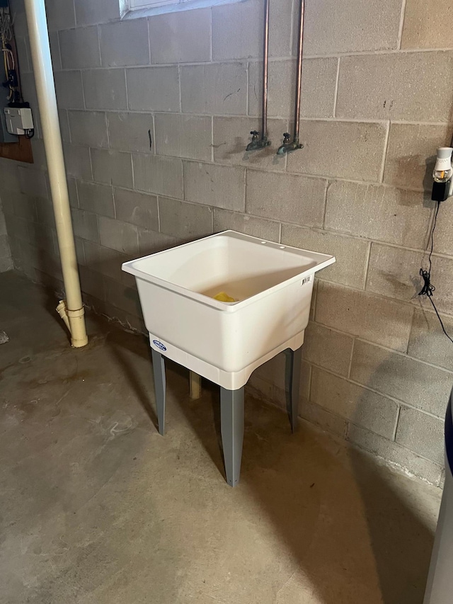 interior details with unfinished concrete flooring and concrete block wall