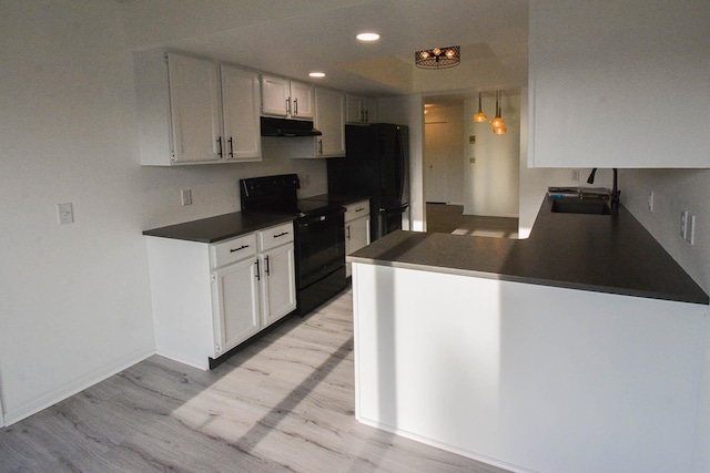 kitchen featuring black appliances, light wood-style flooring, under cabinet range hood, a sink, and dark countertops