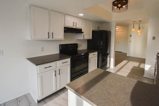 kitchen featuring under cabinet range hood, white cabinets, black appliances, and light wood-type flooring