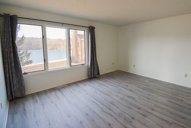 empty room with visible vents and wood finished floors