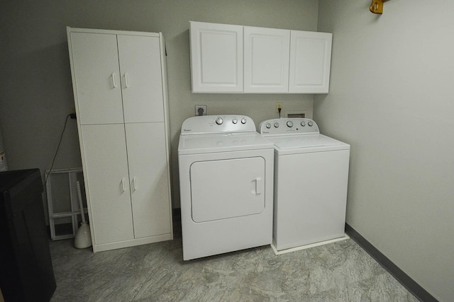 washroom with cabinet space, independent washer and dryer, and baseboards