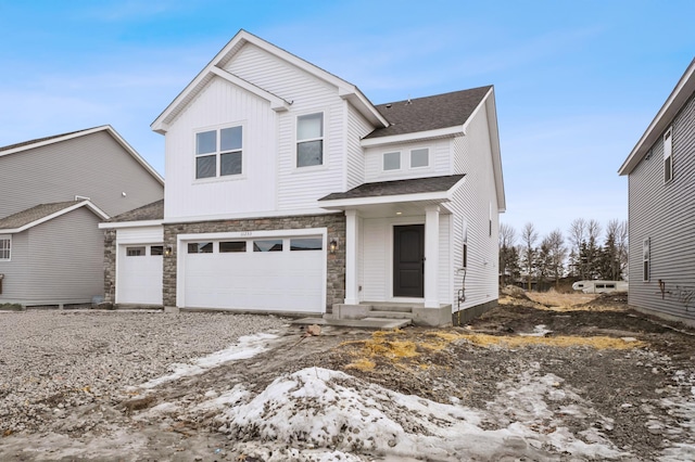 view of front of home with a garage, stone siding, entry steps, and a shingled roof