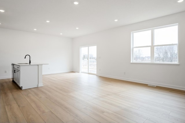 interior space featuring a sink, recessed lighting, and light wood finished floors