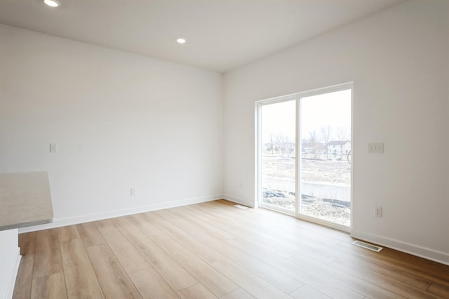 empty room with light wood-type flooring, plenty of natural light, and baseboards