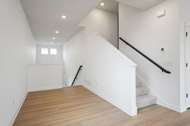 stairway featuring recessed lighting, visible vents, baseboards, and wood finished floors