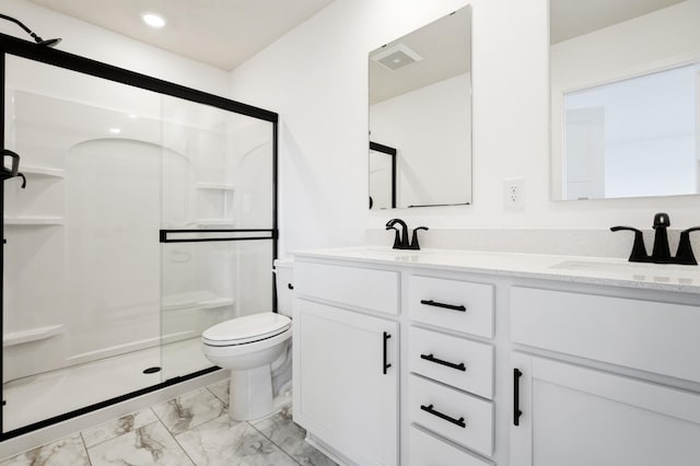 bathroom featuring marble finish floor, toilet, a shower stall, and a sink