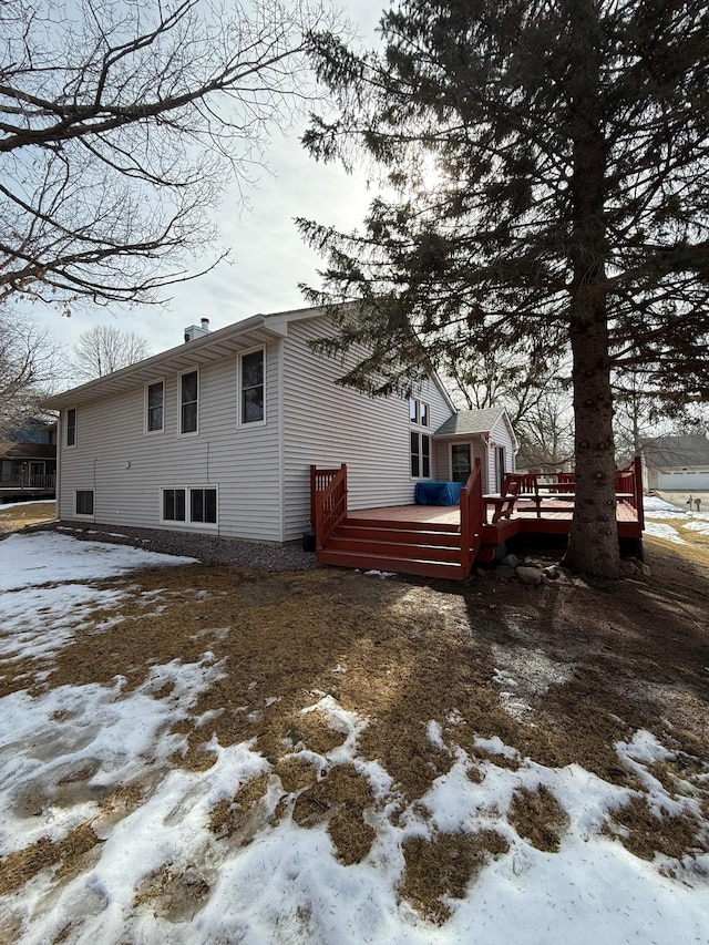 snow covered house with a deck