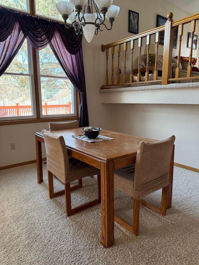 carpeted dining area featuring baseboards and an inviting chandelier