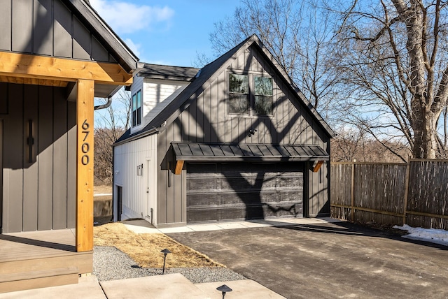 garage featuring driveway and fence