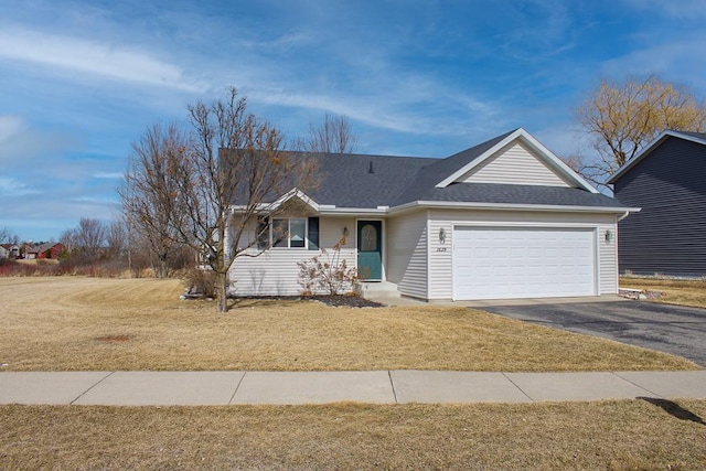 single story home featuring a front lawn, an attached garage, roof with shingles, and driveway