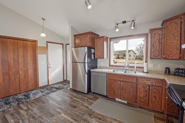 kitchen featuring a sink, light countertops, vaulted ceiling, appliances with stainless steel finishes, and dark wood-style flooring