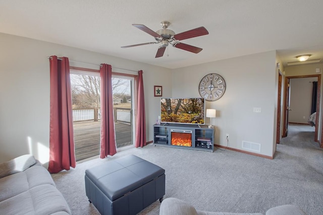 living area with visible vents, carpet flooring, a fireplace, and baseboards