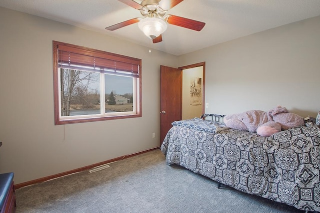 bedroom with baseboards, carpet floors, visible vents, and a ceiling fan