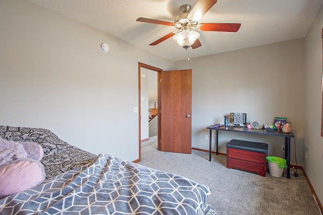 carpeted bedroom featuring a textured ceiling, a ceiling fan, and baseboards