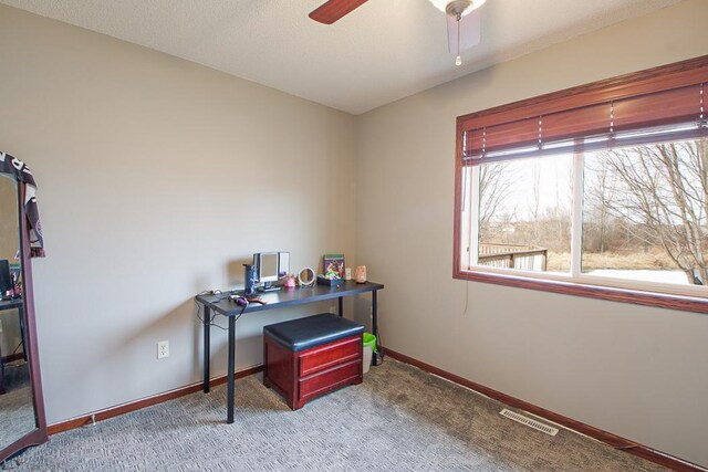 carpeted home office featuring a ceiling fan, baseboards, and visible vents