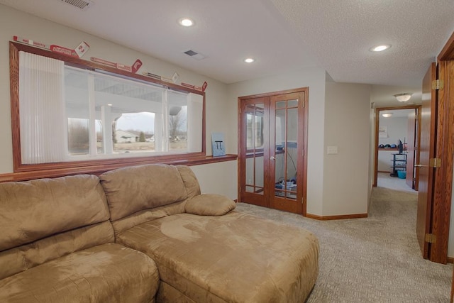 carpeted living room with baseboards, visible vents, recessed lighting, french doors, and a textured ceiling