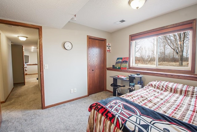 carpeted bedroom featuring visible vents, baseboards, a textured ceiling, and a closet