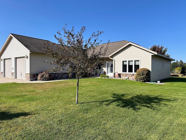 view of front of home with a garage, stone siding, and a front lawn