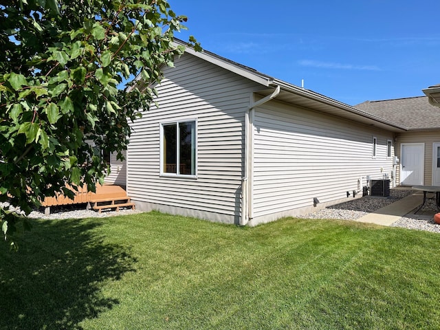 view of property exterior with a lawn, cooling unit, and a deck