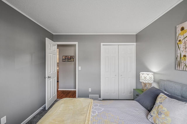 bedroom with visible vents, baseboards, a closet, and crown molding