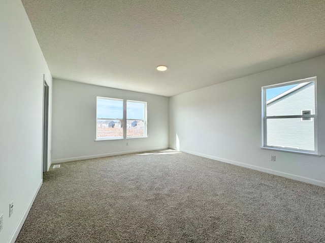 empty room with baseboards, carpet floors, and a textured ceiling