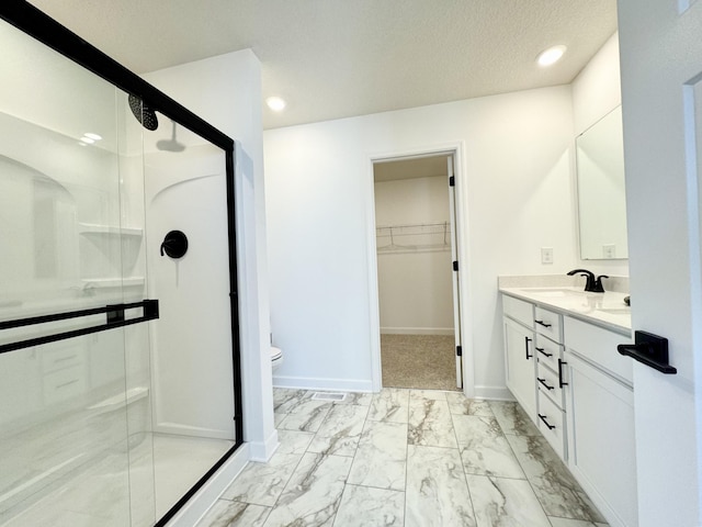 bathroom featuring baseboards, marble finish floor, a stall shower, and vanity