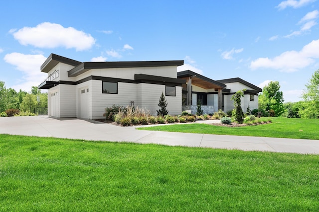 view of front of house with a front lawn, concrete driveway, and an attached garage