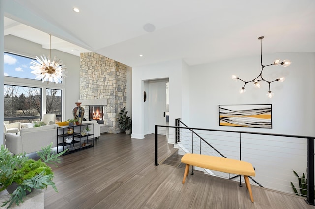 interior space with recessed lighting, lofted ceiling, an inviting chandelier, and wood finished floors