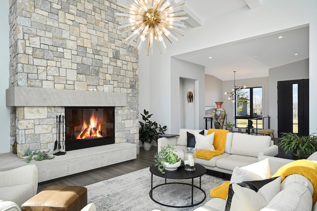 living area with a stone fireplace, an inviting chandelier, recessed lighting, and wood finished floors