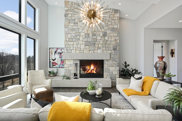 living room featuring a notable chandelier, a fireplace, and wood finished floors