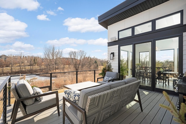 wooden deck with an outdoor hangout area and a water view