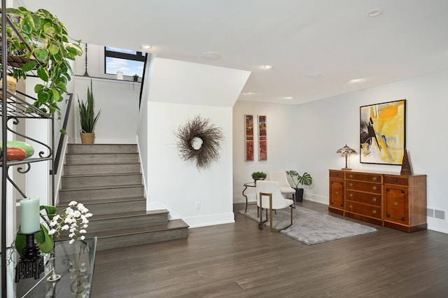 living area featuring stairs, wood finished floors, visible vents, and baseboards