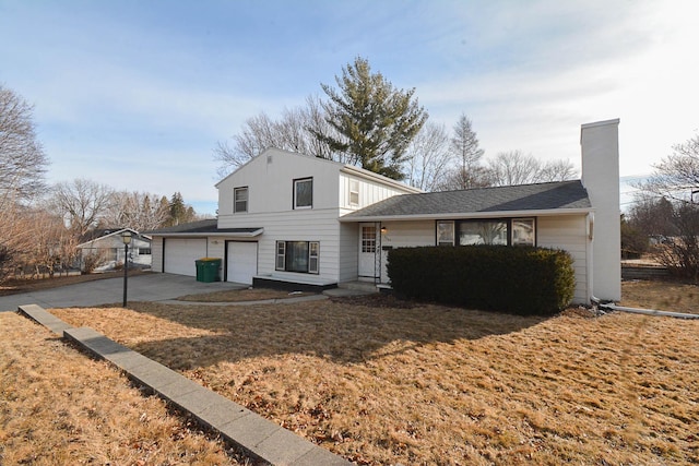 view of front facade with a chimney, concrete driveway, and a garage