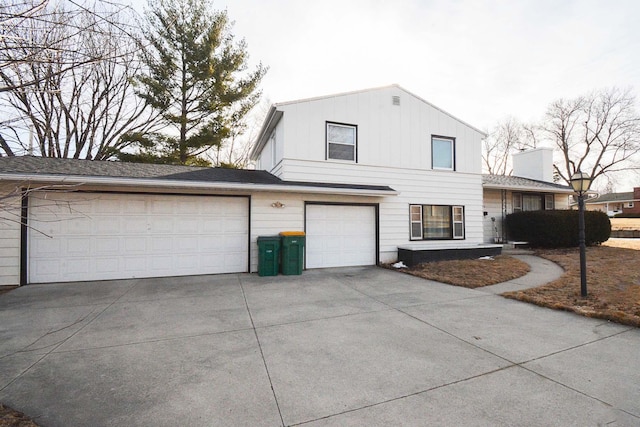 view of side of home with driveway, a garage, and board and batten siding