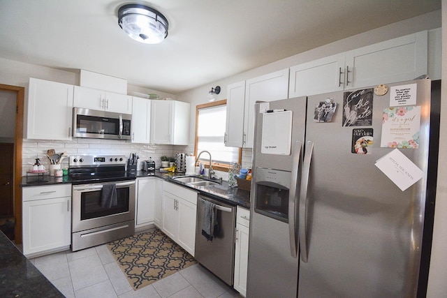 kitchen with a sink, stainless steel appliances, white cabinets, and decorative backsplash