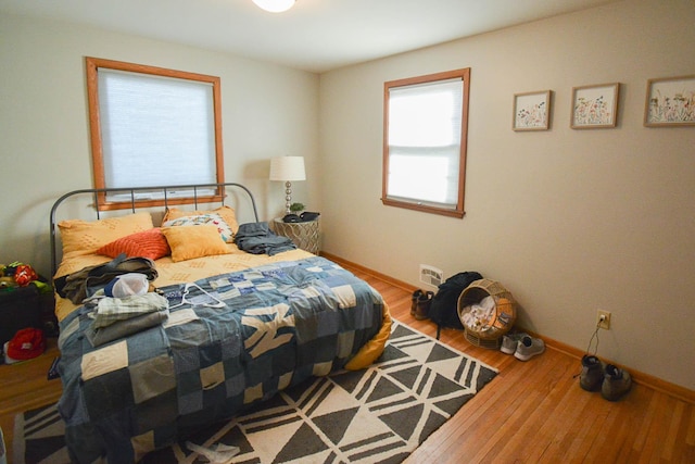 bedroom featuring baseboards and wood finished floors