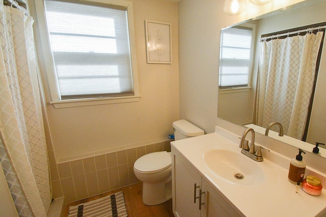 bathroom featuring curtained shower, toilet, vanity, and wood finished floors