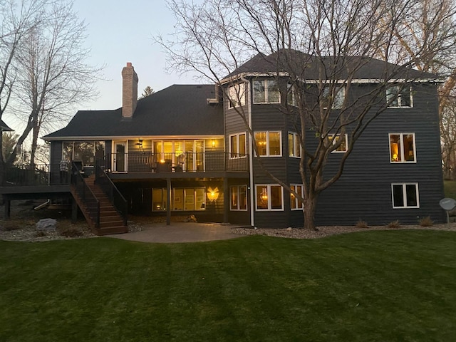 rear view of house featuring a patio area, a wooden deck, and a yard