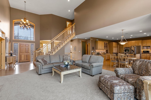 living area with stairway, light carpet, recessed lighting, light wood-style flooring, and a notable chandelier